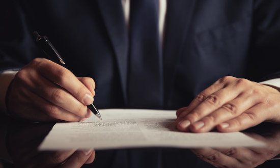 Contratto NDA e lucchetto digitale su tastiera che simboleggiano la protezione del know-how aziendale e del segreto commerciale.